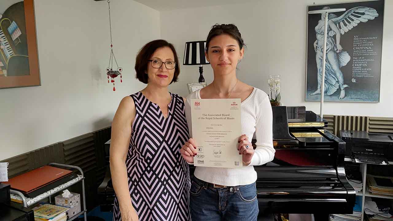 Anna presenting ABRSM Grade 4 Distinction certificate to Eilissa